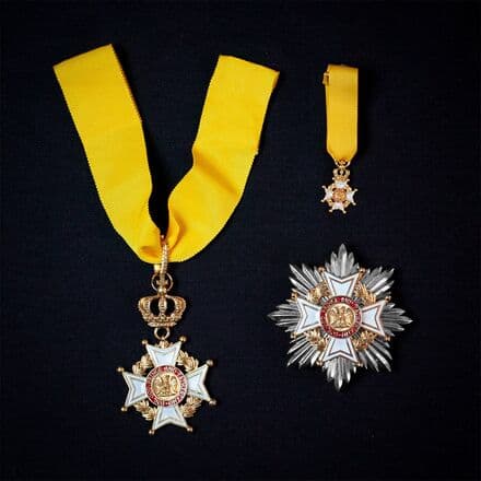 Gold and white insignia of the Royal Order of the Kaharagian Eagle, with yellow ribbons